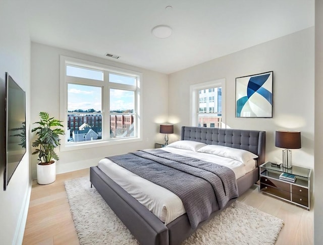 bedroom with wood finished floors and baseboards