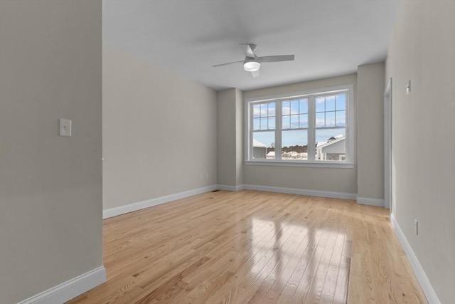 spare room with a water view, ceiling fan, and light wood-type flooring