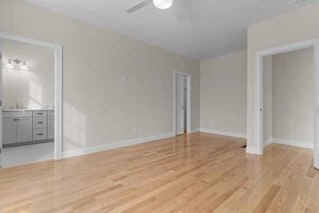 unfurnished bedroom with ceiling fan, ensuite bathroom, sink, and light hardwood / wood-style flooring