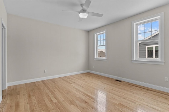 empty room featuring ceiling fan, light hardwood / wood-style flooring, and a healthy amount of sunlight