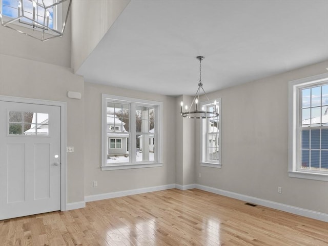 foyer entrance featuring an inviting chandelier and light hardwood / wood-style floors