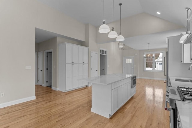 kitchen with white cabinetry, sink, a center island, and pendant lighting