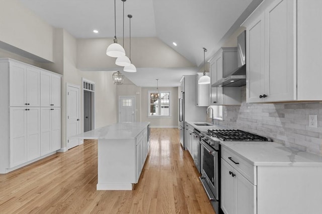 kitchen with white cabinetry, premium appliances, and decorative light fixtures