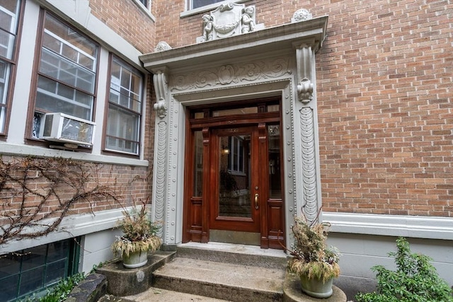doorway to property with cooling unit and brick siding
