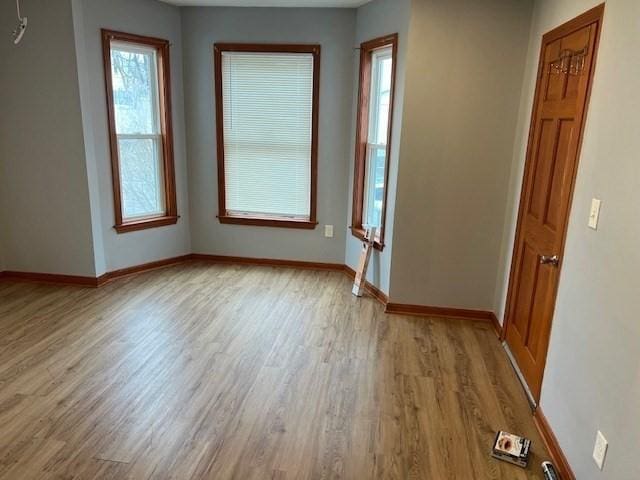 unfurnished room featuring light wood-type flooring and baseboards