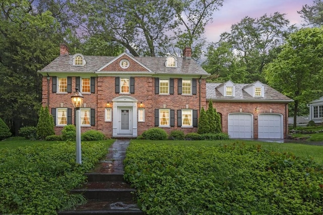 84 Englewood Rd, Longmeadow, MA 01106 - colonial home with a chimney, an attached garage, brick siding, and view of wooded area