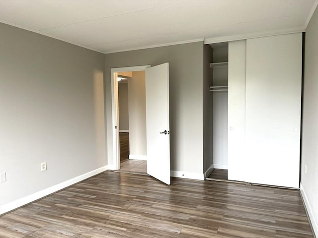 1550 Worcester Rd Unit 524, Framingham, MA 01702 - unfurnished bedroom featuring wood finished floors, ornamental molding, baseboards, and a closet