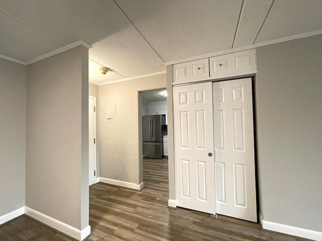 1550 Worcester Rd Unit 524, Framingham, MA 01702 - unfurnished bedroom featuring freestanding refrigerator, crown molding, wood finished floors, baseboards, and a closet