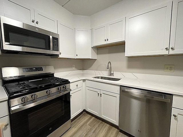 1550 Worcester Rd Unit 524, Framingham, MA 01702 - kitchen with stainless steel appliances, a sink, light wood-style floors, and light stone counters