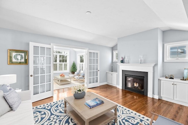 21 Bearberry Path Unit 0, Plymouth, MA 02360 - living area with french doors, wood finished floors, lofted ceiling, a glass covered fireplace, and baseboards