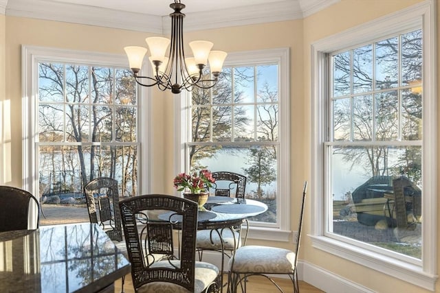 dining area featuring crown molding, a healthy amount of sunlight, and a chandelier