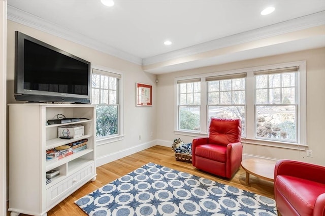 living area with hardwood / wood-style floors, crown molding, and plenty of natural light