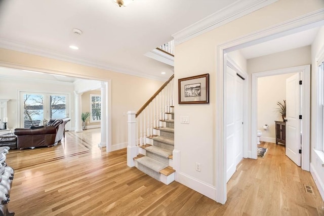 stairs featuring hardwood / wood-style flooring and crown molding