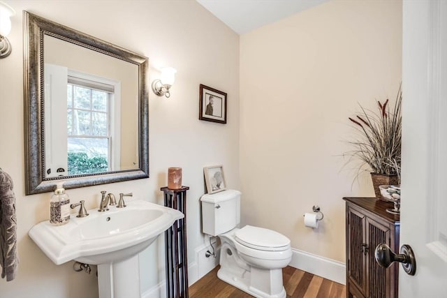 bathroom with sink, hardwood / wood-style flooring, and toilet