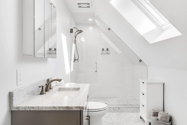 bathroom with vanity, lofted ceiling with skylight, walk in shower, and toilet