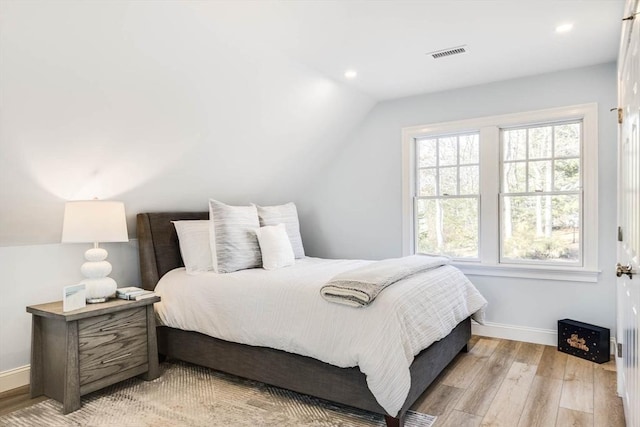 bedroom with vaulted ceiling and light hardwood / wood-style floors