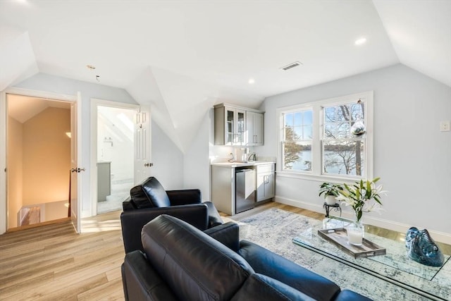 living room with lofted ceiling and light hardwood / wood-style flooring