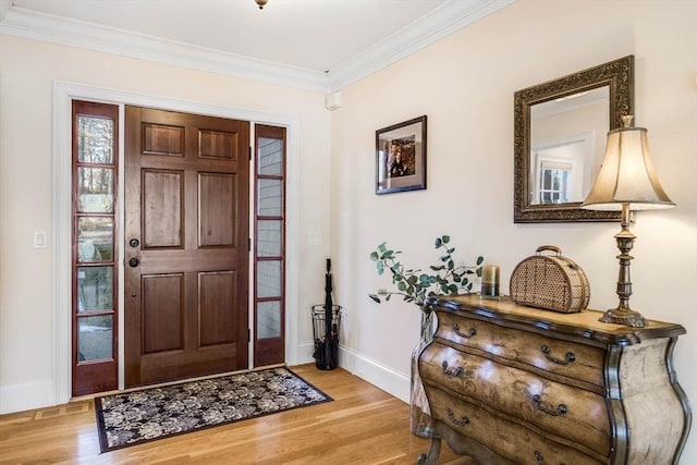 foyer with ornamental molding and light hardwood / wood-style floors