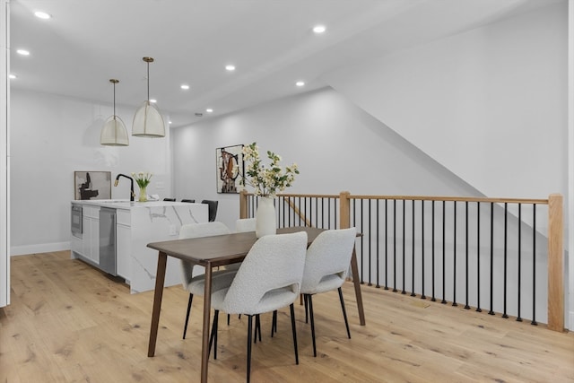 dining room featuring sink and light hardwood / wood-style floors