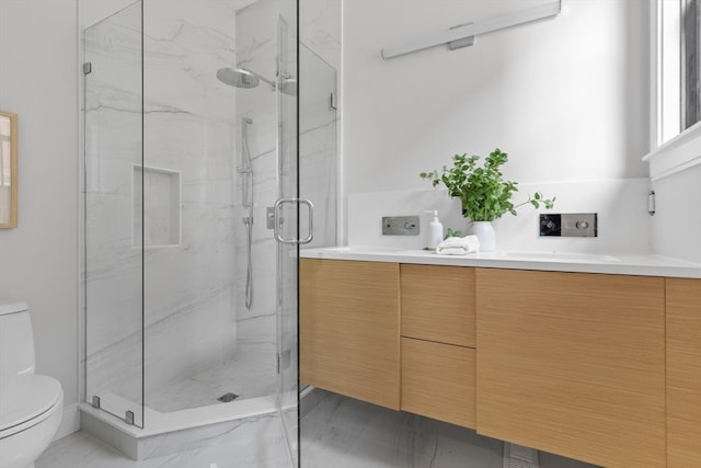 bathroom with vanity, a shower with shower door, and toilet