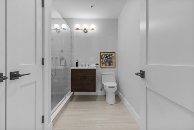 bathroom with vanity, a shower with shower door, and toilet