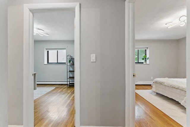 12 Riverside St Unit 1-3, Watertown, MA 02472 - hall with hardwood / wood-style floors, a baseboard heating unit, baseboard heating, and baseboards