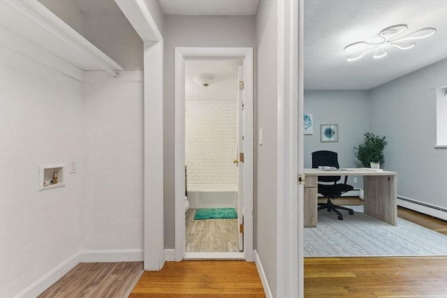 12 Riverside St Unit 1-3, Watertown, MA 02472 - clothes washing area featuring wood finished floors, hookup for a washing machine, an office area, baseboards, and a baseboard radiator