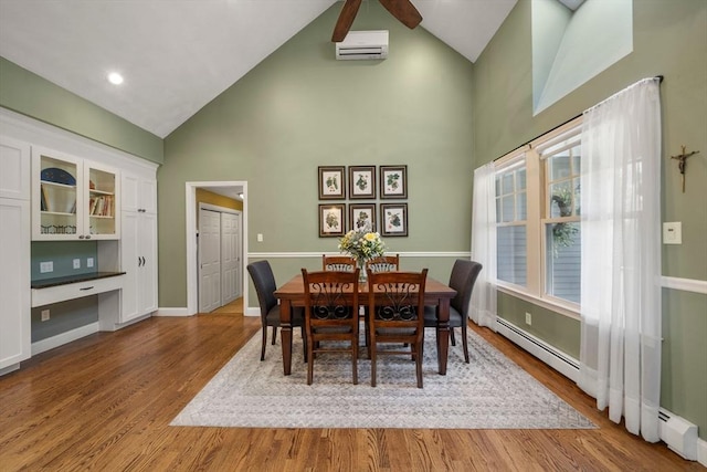 1 Liberty Ln, North Reading, MA 01864 - dining area with high vaulted ceiling, wood finished floors, an AC wall unit, ceiling fan, and built in study area