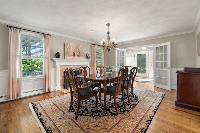 1 Liberty Ln, North Reading, MA 01864 - dining space featuring a chandelier, plenty of natural light, light wood-type flooring, a wainscoted wall, and ornamental molding