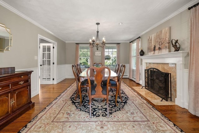 1 Liberty Ln, North Reading, MA 01864 - dining area with light wood-style floors, a chandelier, ornamental molding, wainscoting, and a high end fireplace