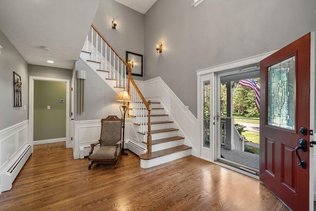 1 Liberty Ln, North Reading, MA 01864 - entrance foyer with a baseboard heating unit, stairway, wood finished floors, a decorative wall, and a wainscoted wall