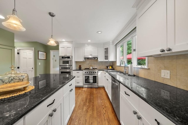 1 Liberty Ln, North Reading, MA 01864 - kitchen featuring stainless steel appliances, light wood-style floors, under cabinet range hood, white cabinets, and decorative light fixtures