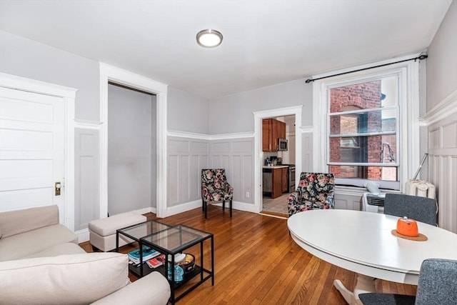 living area with a decorative wall and wood finished floors