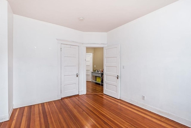 empty room with baseboards and wood finished floors