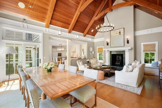 interior space featuring wooden ceiling, plenty of natural light, a fireplace, and a notable chandelier