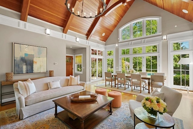 sunroom / solarium with vaulted ceiling with beams, wooden ceiling, and a notable chandelier