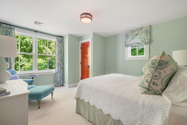 bedroom featuring light carpet, visible vents, and baseboards