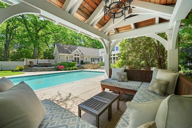 view of swimming pool featuring outdoor lounge area, an outdoor structure, fence, a gazebo, and an exterior structure