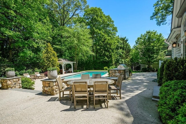 view of swimming pool featuring outdoor dining area, fence, a gazebo, a fenced in pool, and a patio area