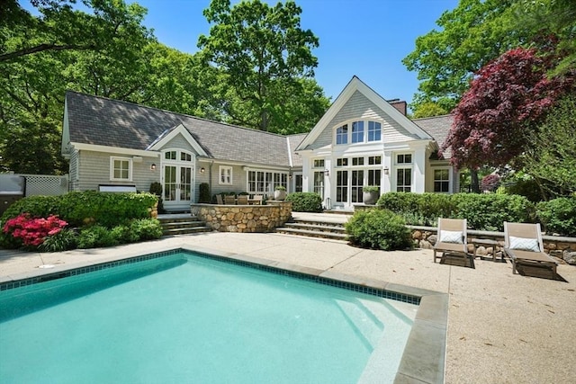 back of property with an outbuilding, a patio, french doors, and an exterior structure