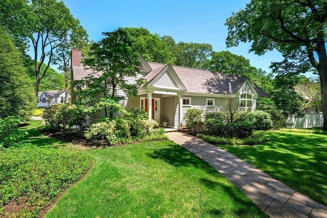 view of front facade with a chimney and a front lawn