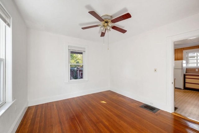 unfurnished room with hardwood / wood-style flooring and ceiling fan