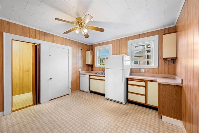 kitchen featuring sink, crown molding, white appliances, ceiling fan, and wooden walls