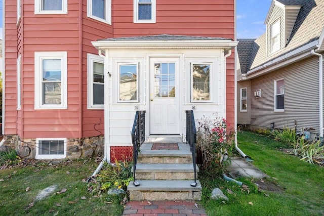 property entrance with a lawn