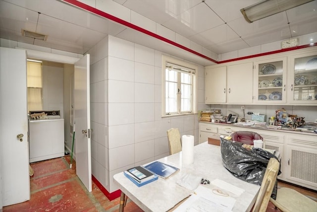 kitchen with glass insert cabinets, washer / dryer, and light countertops