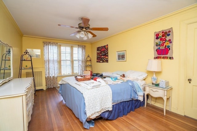 bedroom featuring ornamental molding, ceiling fan, and wood finished floors