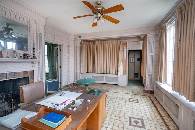 office featuring a ceiling fan, radiator, a fireplace, and crown molding