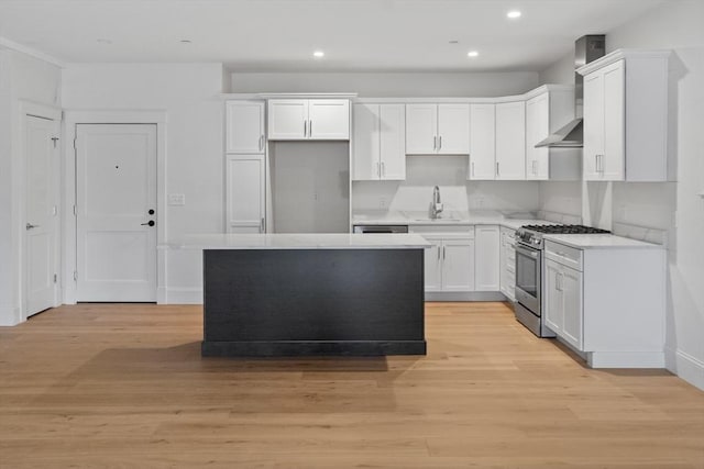 kitchen with sink, light hardwood / wood-style flooring, white cabinetry, and stainless steel range with gas stovetop