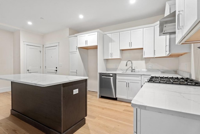 kitchen featuring ventilation hood, white cabinetry, sink, and appliances with stainless steel finishes