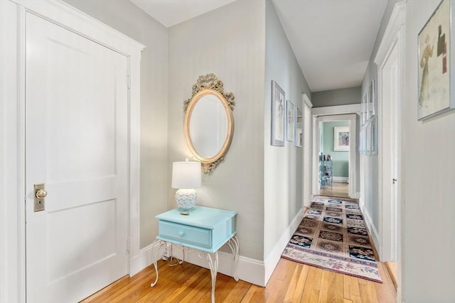 hallway with hardwood / wood-style floors and baseboards